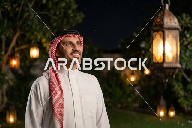 شهر رمضان المبارك، رجل عربي خليجي سعودي يرتدي الزي التقليدي والشماغ  ينظر الى فانوس رمضان، إضاءة وزينة شهر رمضان، أجواء رمضانية، مناسبات دينية ، اسلاميات وعبادات