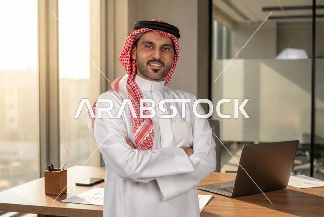 مفهوم الأناقة والإهتمام بالمظهر الخارجي، رجل أعمال عربي خليجي سعودي مبتسم يرتدي الثوب التقليدي والشماغ ينظر الى الكاميرا بتعابير السعاده ، مهن ووظائف ادارية سعودية، توضيح مهام العمل واستراتيجيات الشركة
