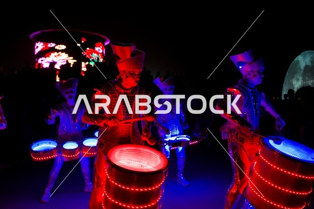 عرض موسيقي ضمن فعاليات خريف صلالة في سلطنة عُمان، عازفو الطبول التقليدية يؤدون إيقاعات شعبية مميزة، ارتداء الزي العُماني التراثي بألوانه ونقوشه الأصيلة، أجواء احتفالية نابضة بالحياة، تفاعل جماهيري، فعاليات ثقافية تعكس الهوية العُمانية وروح موسم الخريف في صلالة.