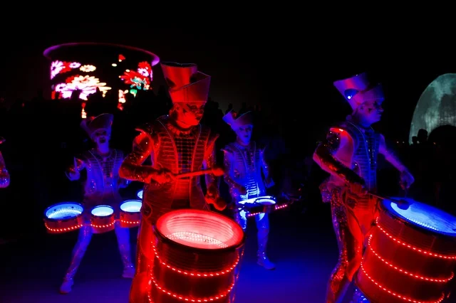 A musical performance as part of the Salalah Khareef events in the Sultanate of Oman, traditional drummers perform distinctive popular rhythms, wearing the traditional Omani attire with its authentic colors and patterns, a vibrant festive atmosphere, public interaction, and cultural activities that reflect the Omani identity and the spirit of the autumn season in Salalah.
