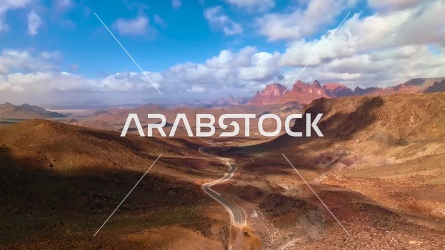 The formations and rock structures in the mountainous valleys of famous historical archaeological sites, a winding road that cuts through the mountains in Wadi Al-Disa in the Tabuk region, the land of palm trees and enchanting springs, mountain ranges and natural landmarks in Saudi Arabia, the tourist areas in the Kingdom.