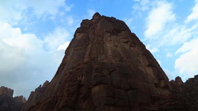 قمة جبلية صخرية في شمال المملكة العربية السعودية ، مناظر طبيعية  للرمال الذهبية ، جبال ذات تشكيلات صخرية جذابة في تبوك ، معالم حضارية سياحية في المملكة العربية السعودية .