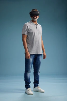 A Saudi Arabian Gulf Arab man wearing casual attire is using virtual reality glasses, watching movies and entertaining videos through VR, full body, with a blue background. A Saudi Arabian Gulf Arab man wearing casual attire is using virtual reality glasses, watching movies and entertaining videos through VR, full body, with a blue background.