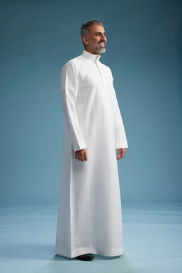 رجل عربي  سعودي خليجي يرتدي ثوب ابيض  , النظر الى شيء ما, الوقوف بثقه, كامل الجسم, خلفيه زرقاء