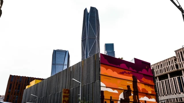 مشهد معاصر لأفق الرياض العمراني، أبراج المركز المالي الزجاجية و الشاهقة بتصاميم هندسية فريدة، محاطة بعناصر فنية حديثة، رمز للتطور الاقتصادي والنهضة المعمارية في المملكة العربية السعودية