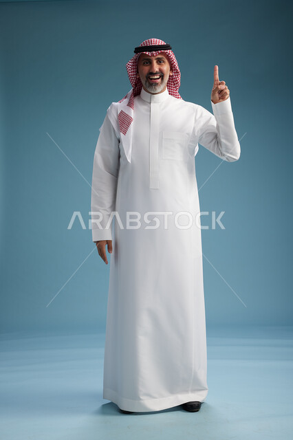 بورتريه لرجل  عربي سعودي  خليجي واثق يرتدي الثوب الابيض والشماغ  ويبتسم, اشارات وحركات متنوعه, خلفيه زرقاء