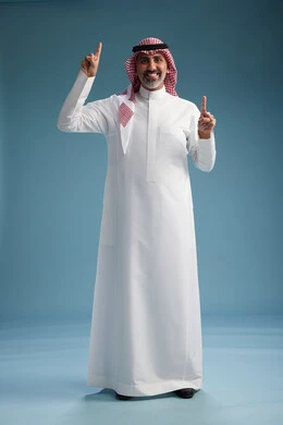 بورتريه لرجل  عربي سعودي  خليجي واثق يرتدي الثوب الابيض والشماغ  ويبتسم, اشارات وحركات متنوعه, خلفيه زرقاء