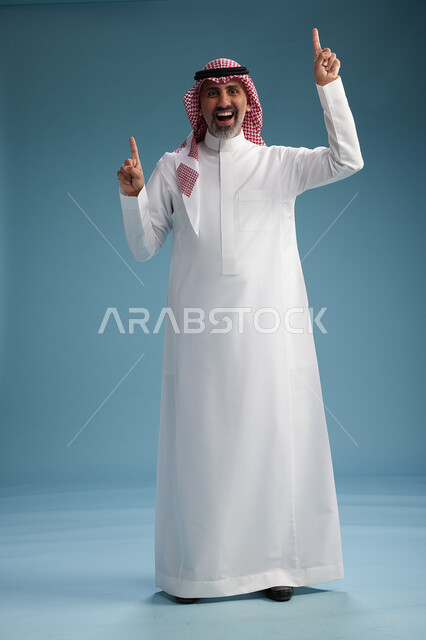 بورتريه لرجل  عربي سعودي  خليجي واثق يرتدي الثوب الابيض والشماغ  ويبتسم, اشارات وحركات متنوعه, خلفيه زرقاء