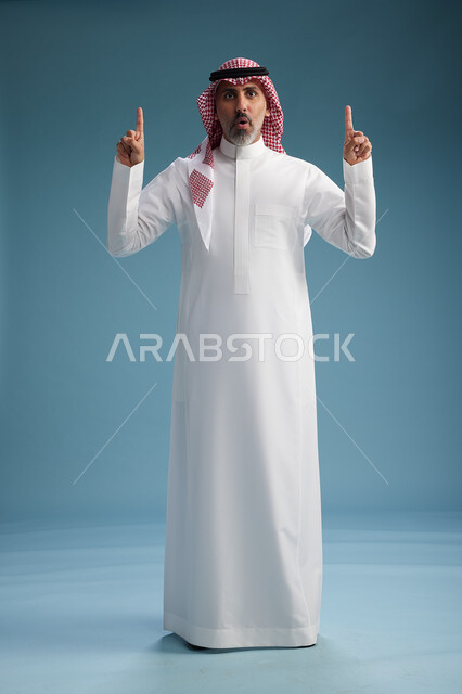 A portrait of a confident Arab Saudi Gulf man wearing a white thobe and a shemagh, smiling, with various gestures and movements, against a blue background.