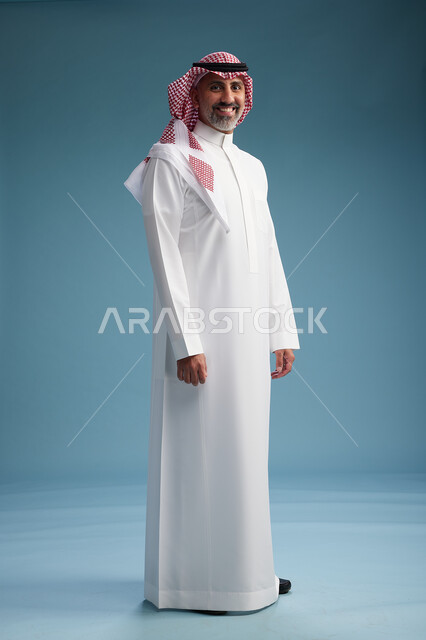 بورتريه لرجل  عربي سعودي  خليجي واثق يرتدي الثوب الابيض والشماغ  ويبتسم, اشارات وحركات متنوعه, خلفيه زرقاء
