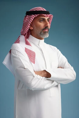 A portrait of a confident Arab Saudi Gulf man wearing a white thobe and a shemagh, smiling, with various gestures and movements, against a blue background.