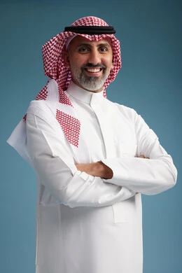 A portrait of a confident Arab Saudi Gulf man wearing a white thobe and a shemagh, smiling, with various gestures and movements, against a blue background.