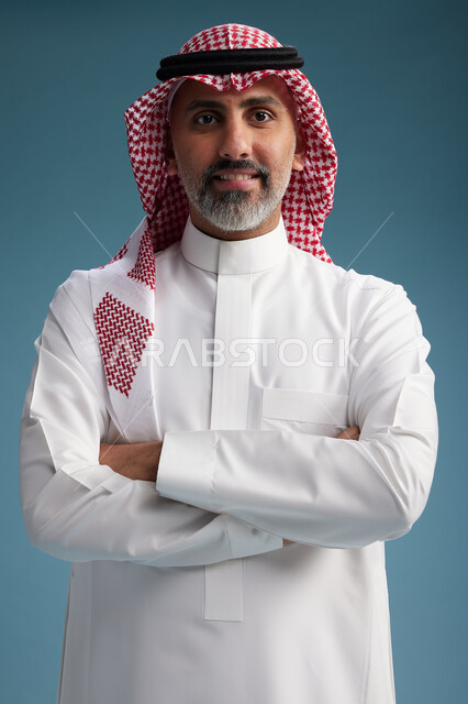 بورتريه لرجل  عربي سعودي  خليجي واثق يرتدي الثوب الابيض والشماغ  ويبتسم, اشارات وحركات متنوعه, خلفيه زرقاء