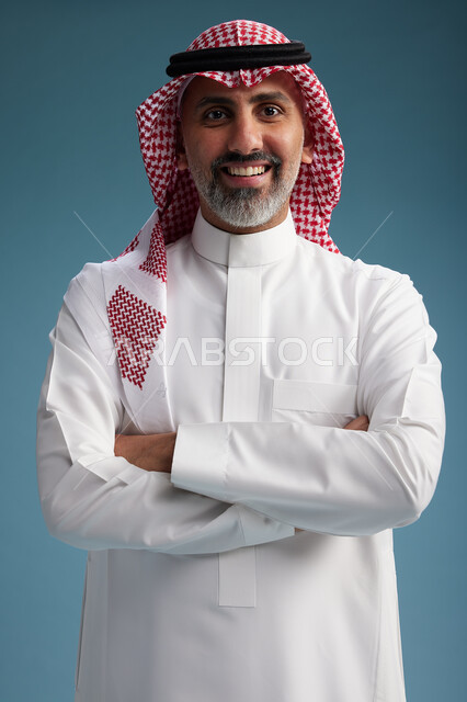 بورتريه لرجل  عربي سعودي  خليجي واثق يرتدي الثوب الابيض والشماغ  ويبتسم, اشارات وحركات متنوعه, خلفيه زرقاء