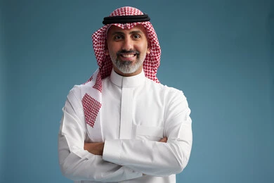 A portrait of a confident Arab Saudi Gulf man wearing a white thobe and a shemagh, smiling, with various gestures and movements, against a blue background.