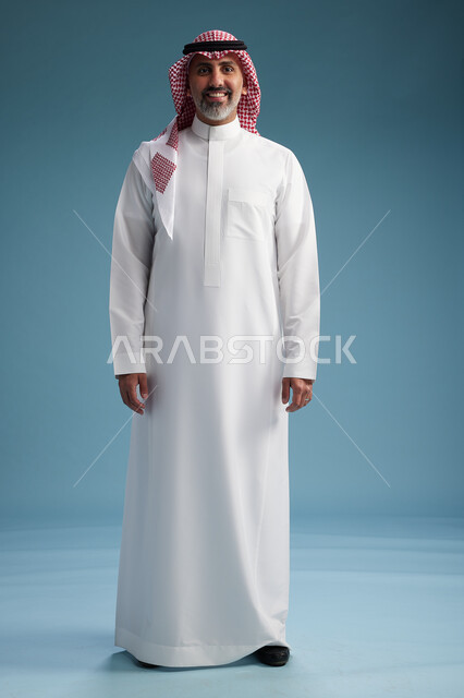 بورتريه لرجل  عربي سعودي  خليجي واثق يرتدي الثوب الابيض والشماغ  ويبتسم, اشارات وحركات متنوعه, خلفيه زرقاء