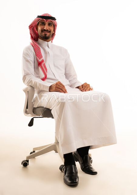 رجل سعودي بالزي التقليدي يجلس على كرسي مكتب
