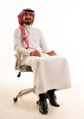 رجل سعودي بالزي التقليدي يجلس على كرسي مكتب