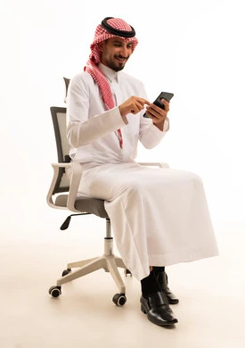 رجل سعودي يستخدم الهاتف الذكي على كرسي مكتب خلفية بيضاء
