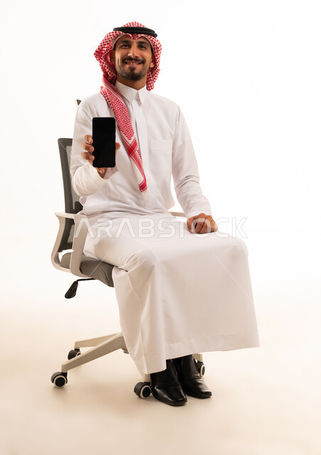 Saudi Man Holding Smartphone in Office Chair