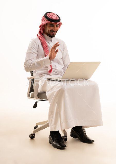 رجل سعودي بالثوب يلوح خلال مكالمة فيديو محمول