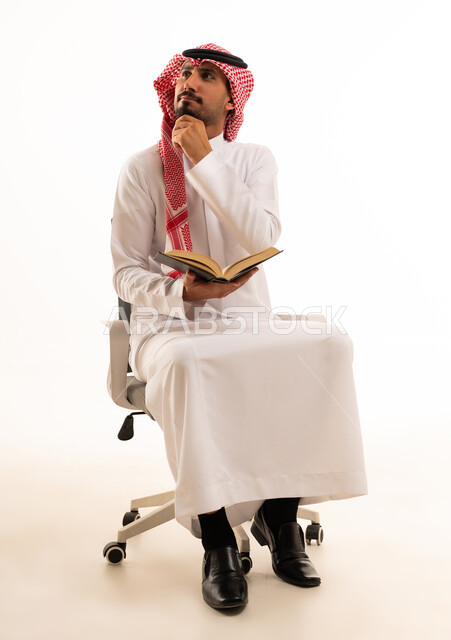 Saudi Man in Traditional Thobe Thinking with Book