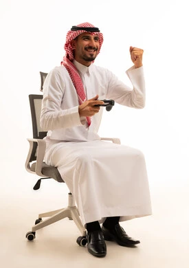 رجل سعودي يلعب ألعاب الفيديو مع إيماءة فوز