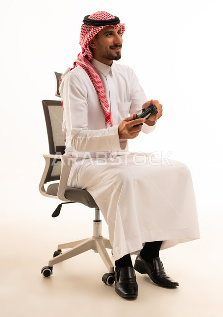 رجل سعودي يلعب ألعاب الفيديو بالزي التقليدي