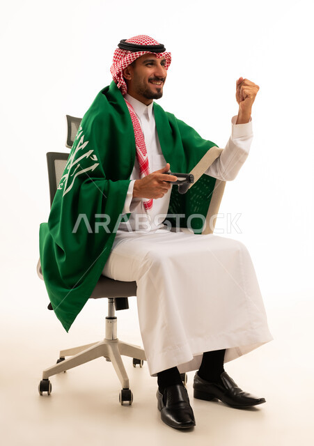 رجل سعودي يحتفل بالفوز بالألعاب مع العلم الوطني