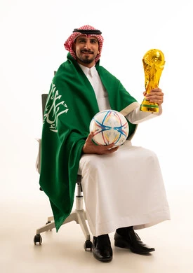 رجل سعودي مع العلم وكأس كرة القدم