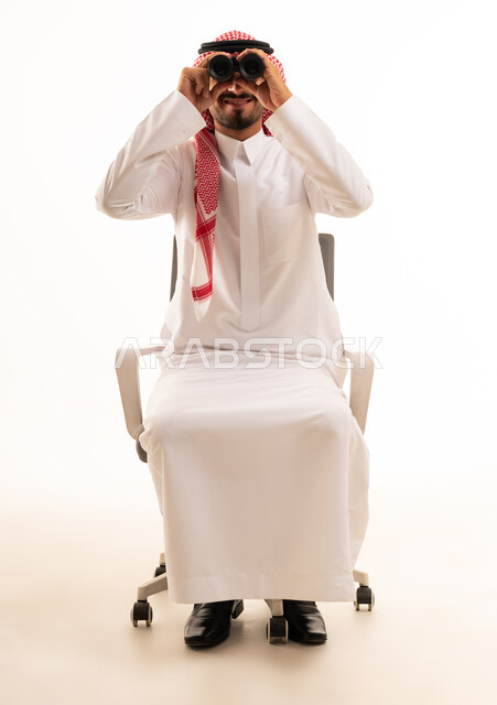 رجل سعودي يستخدم المنظار على كرسي مكتب