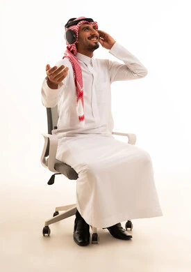 رجل سعودي بالثوب التقليدي يستمع للموسيقى