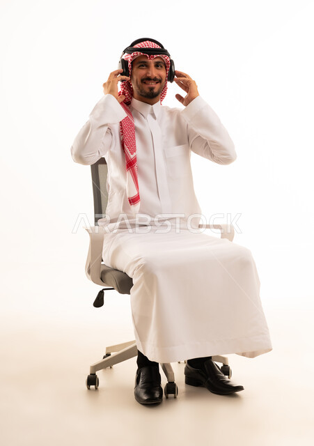 رجل سعودي بالزي التقليدي يرتدي سماعات رأس