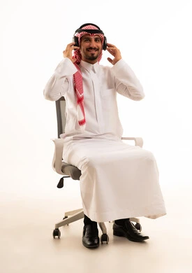 Saudi Man in Traditional Dress with Headphones