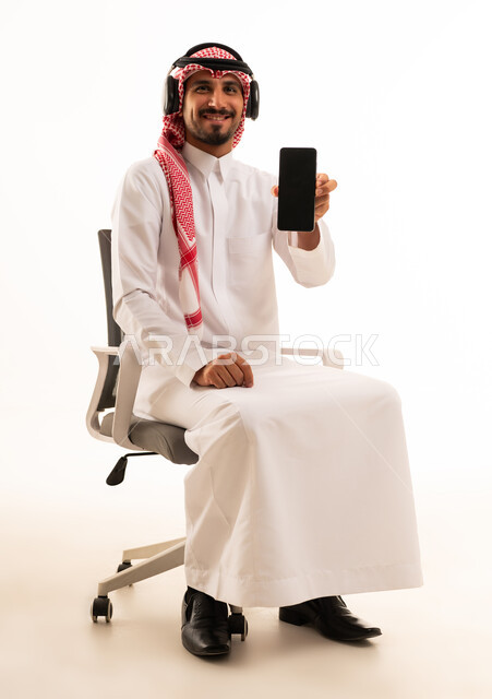 Saudi Man Holding Smartphone Wearing Headphones