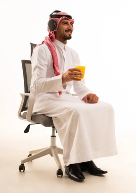 Saudi Man with Headphones Drinking Juice on Office Chair