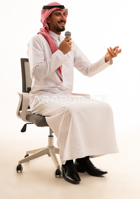 رجل سعودي بالزي التقليدي يتحدث عبر الميكروفون