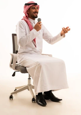 رجل سعودي بالزي التقليدي يتحدث عبر الميكروفون