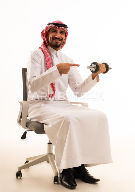 رجل سعودي بالزي التقليدي يرفع أثقال رياضية