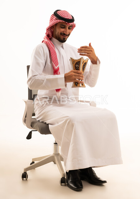 رجل سعودي مع مبخرة على كرسي مكتب