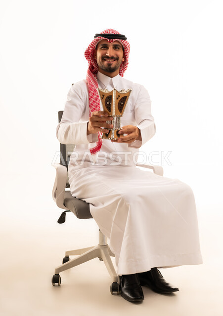 رجل سعودي يحمل مبخرة تقليدية في الاستوديو