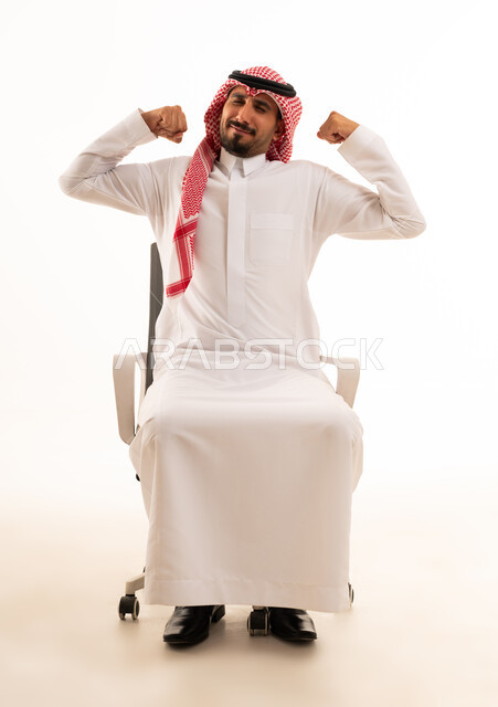 رجل سعودي يستعرض عضلاته على كرسي مكتب