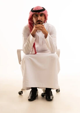 Saudi Man in Traditional Attire Sitting on Office Chair