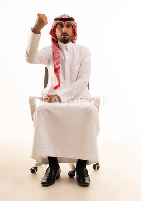 رجل سعودي بالزي التقليدي يرفع قبضة يده