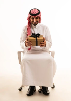 Saudi Man in Traditional Dress Holding Gift Box