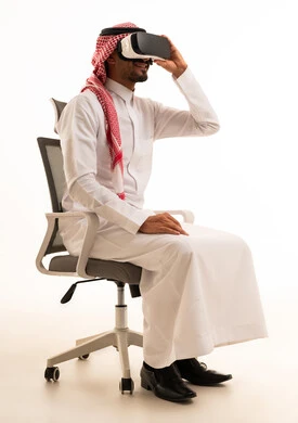 رجل سعودي بالزي التقليدي يستخدم نظارة الواقع الافتراضي