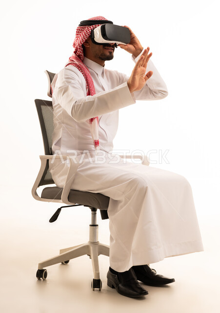 رجل سعودي يستخدم نظارات الواقع الافتراضي بالزي التقليدي