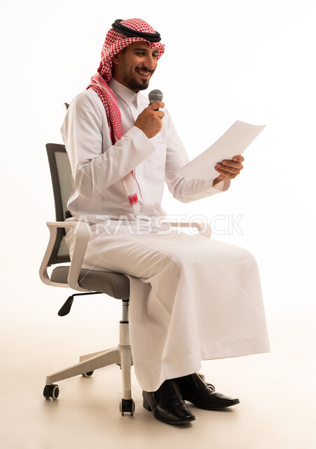 رجل سعودي مع ميكروفون وورقة في الاستوديو