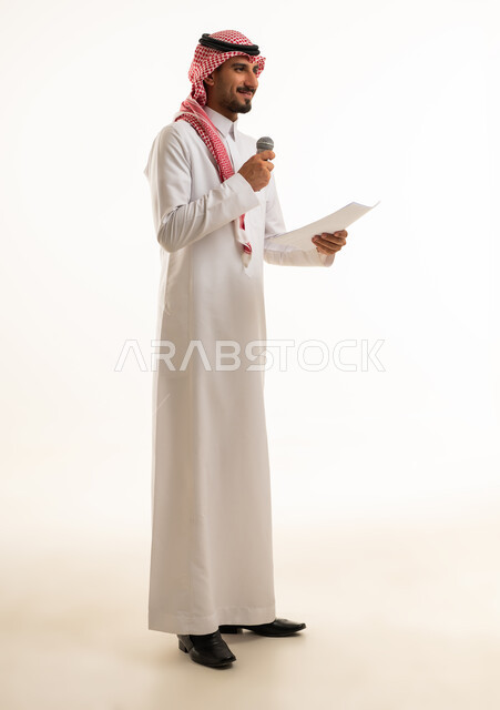 Saudi Man Holding Microphone and Paper in Studio