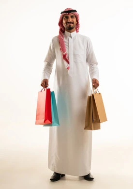 رجل سعودي يحمل أكياس تسوق في الاستوديو